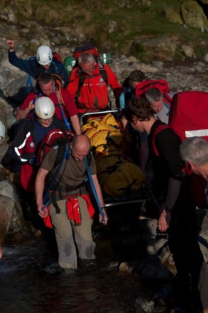 Team members carrying the stretcher through the beck