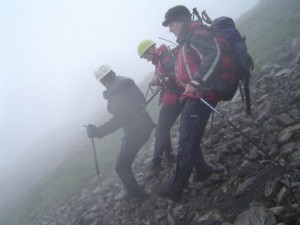 Cragfast walker is assisted off the scree by use of climbing harness and tapes Cragfast walker is assisted off the scree by use of climbing harness and tapes