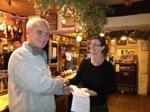 Team chairman Richard Warren accepting the cheque from Lesley at the  team dinner