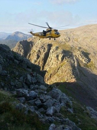 The Sea King lowering the winchman to the stuck climber. 