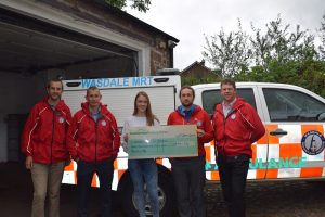 Team members receive cheque from apprentice Abigail Elsworth